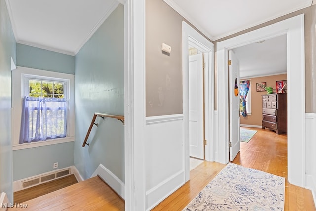 corridor featuring crown molding and light hardwood / wood-style floors