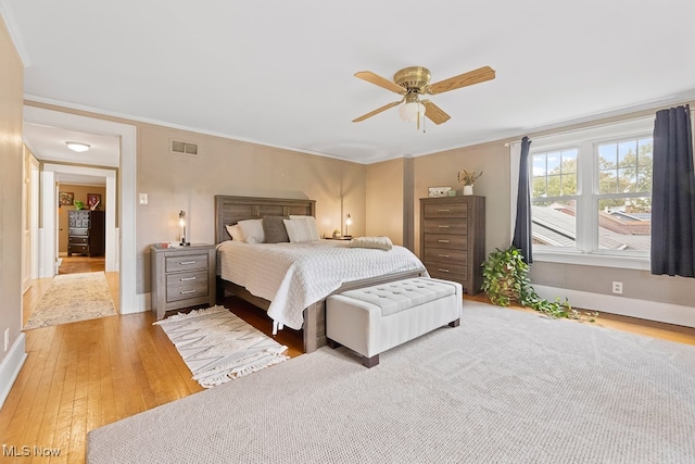 bedroom featuring hardwood / wood-style flooring, crown molding, and ceiling fan