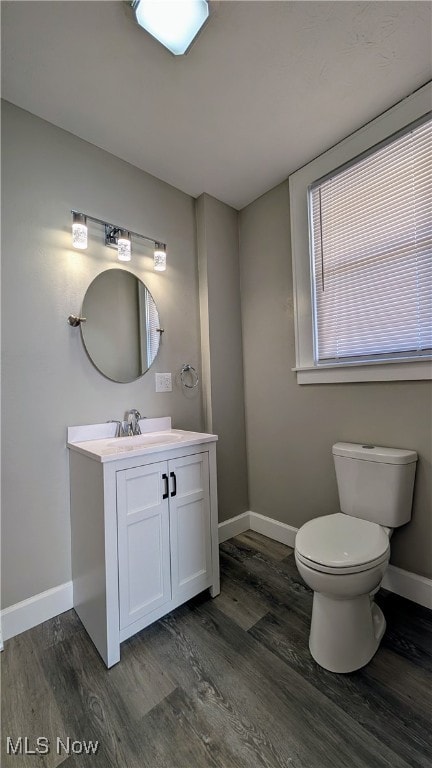 bathroom with hardwood / wood-style flooring, vanity, and toilet