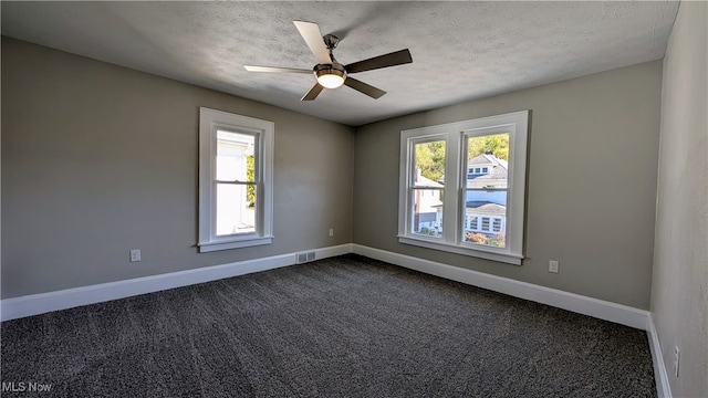 empty room with ceiling fan, carpet flooring, and a textured ceiling