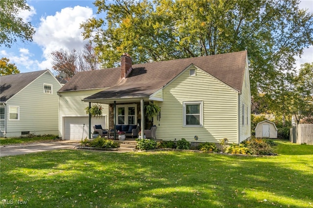 view of front of property featuring a front lawn, a porch, a storage shed, and a garage