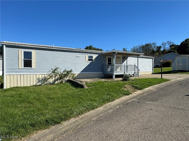 manufactured / mobile home featuring a storage shed and a front yard