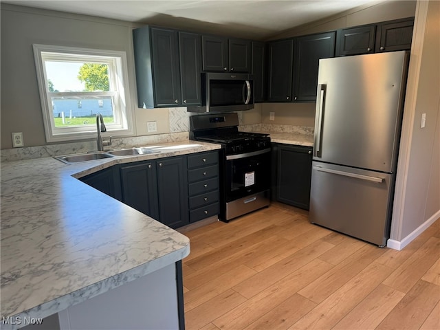 kitchen featuring sink, appliances with stainless steel finishes, and light hardwood / wood-style flooring