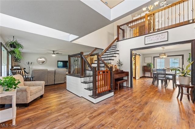 stairs featuring a skylight, ceiling fan, and wood-type flooring