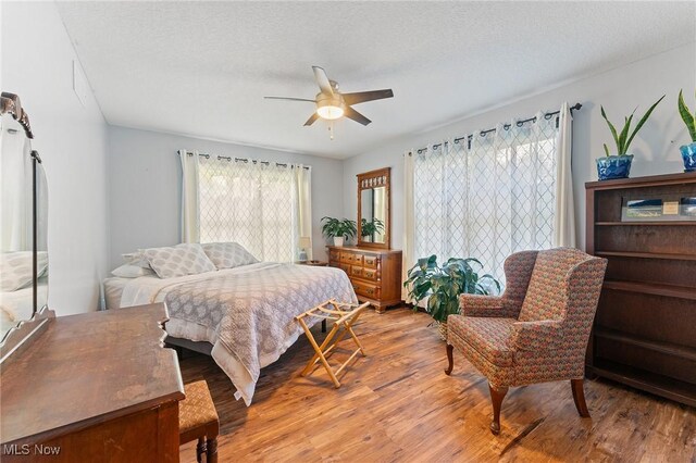 bedroom featuring ceiling fan, a textured ceiling, and wood-type flooring