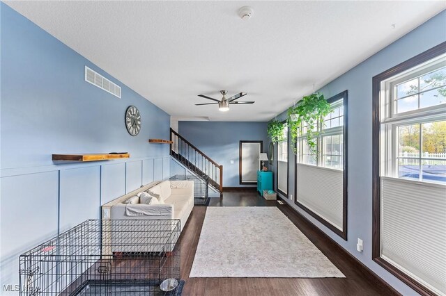 unfurnished living room featuring dark wood-type flooring and ceiling fan