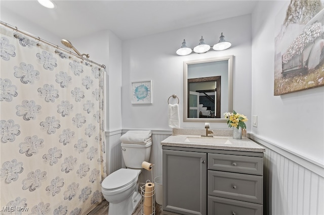 bathroom with walk in shower, vanity, hardwood / wood-style floors, and toilet