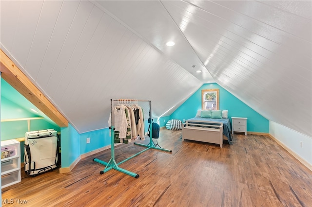 exercise room featuring lofted ceiling and wood-type flooring