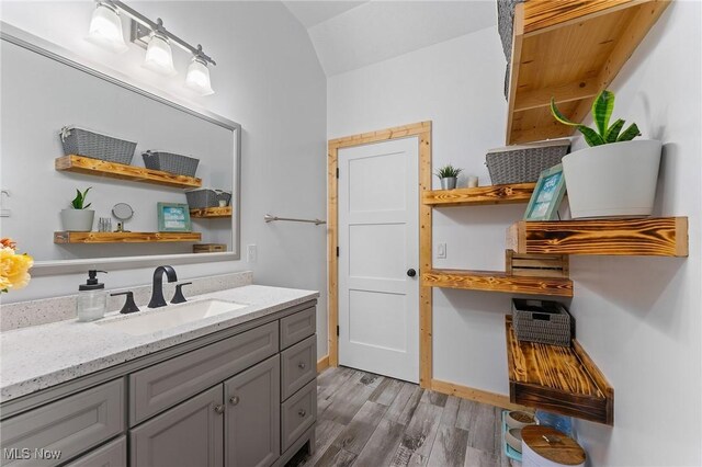 bathroom featuring vaulted ceiling, vanity, and hardwood / wood-style floors