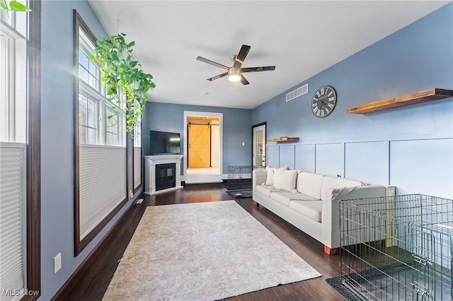 living room featuring ceiling fan and dark hardwood / wood-style flooring