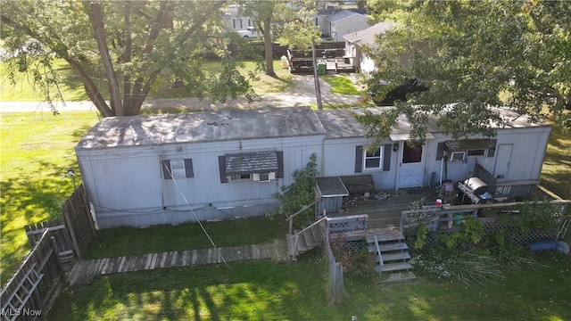 back of property with a wooden deck and a lawn