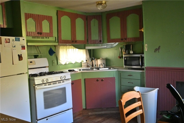 kitchen featuring dark wood-type flooring, white appliances, and sink