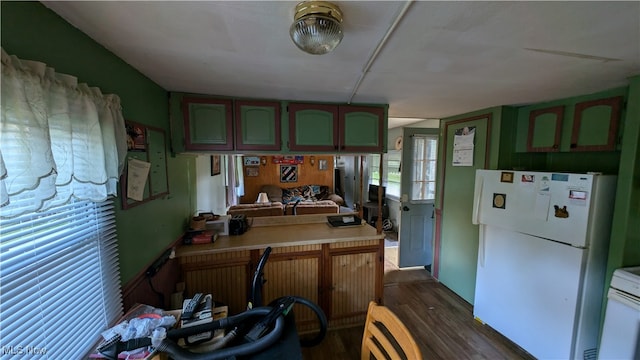 kitchen featuring dark hardwood / wood-style floors, kitchen peninsula, and white appliances