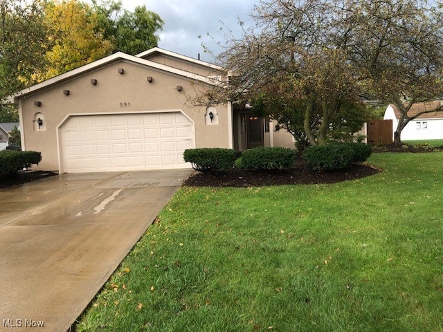 view of front of house with a garage and a front lawn