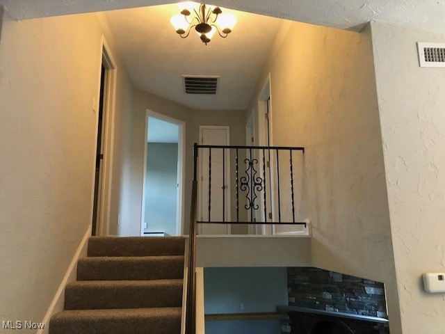 staircase featuring an inviting chandelier