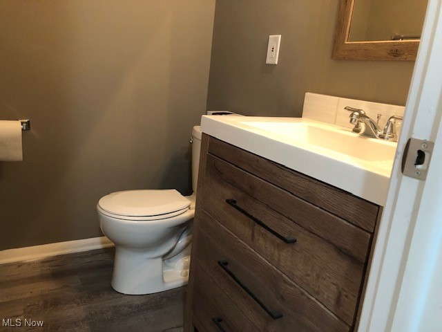 bathroom featuring hardwood / wood-style floors, vanity, and toilet