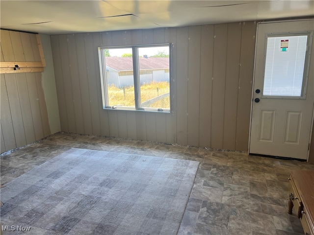 foyer entrance with wooden walls