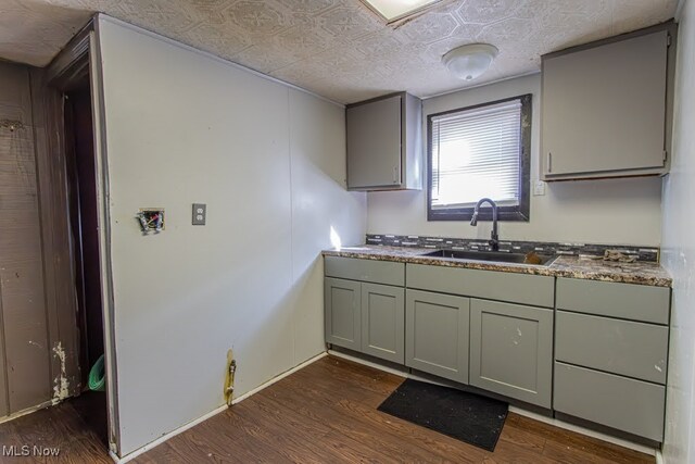 kitchen featuring gray cabinets, sink, dark hardwood / wood-style flooring, and a textured ceiling