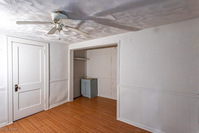 unfurnished bedroom with ceiling fan and light hardwood / wood-style flooring