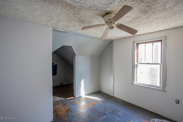 bonus room with ceiling fan, a textured ceiling, vaulted ceiling, and dark hardwood / wood-style flooring