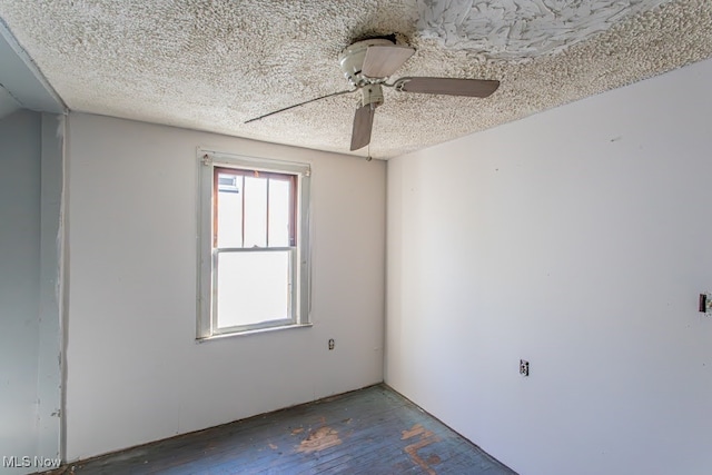 empty room with ceiling fan, hardwood / wood-style floors, and a textured ceiling