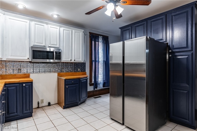 kitchen featuring butcher block countertops, tasteful backsplash, appliances with stainless steel finishes, and white cabinets