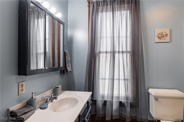 bathroom featuring a healthy amount of sunlight, vanity, and toilet