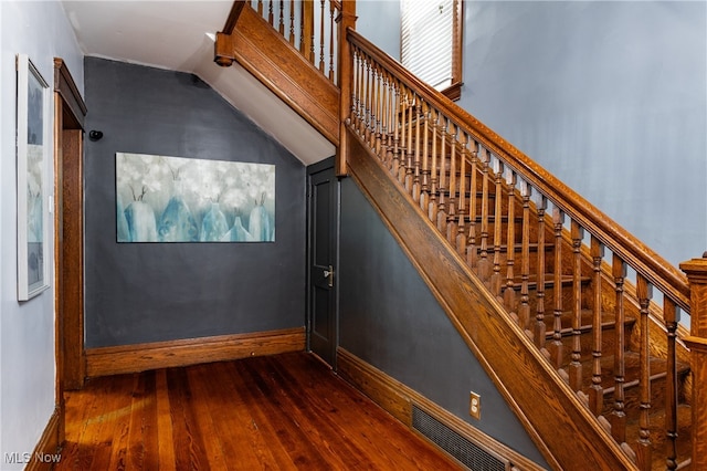 stairway with hardwood / wood-style flooring and lofted ceiling