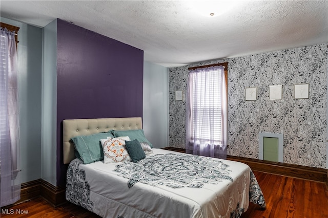 bedroom featuring a textured ceiling and dark wood-type flooring