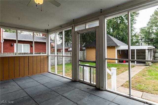 unfurnished sunroom featuring ceiling fan