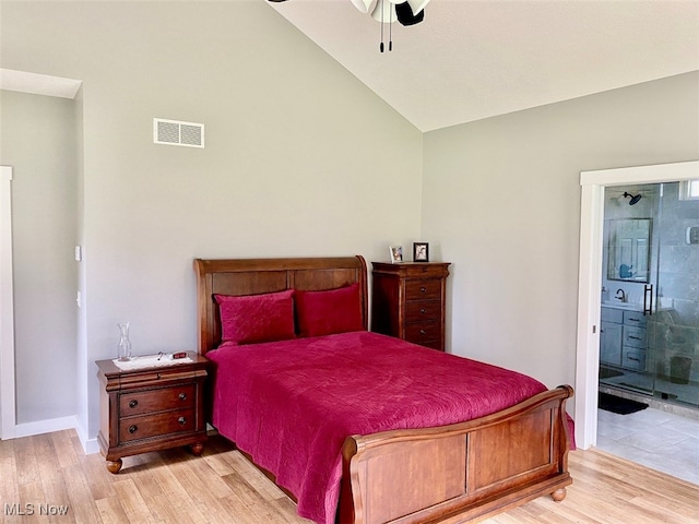 bedroom with ceiling fan, light hardwood / wood-style flooring, ensuite bath, and lofted ceiling