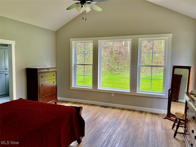 bedroom featuring ceiling fan, light hardwood / wood-style flooring, vaulted ceiling, and multiple windows