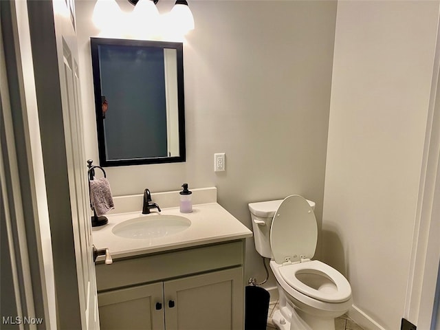 bathroom with tile patterned flooring, vanity, and toilet