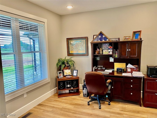 office space with light wood-type flooring and a healthy amount of sunlight