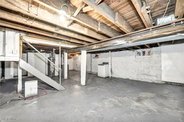 basement with water heater and washer / dryer