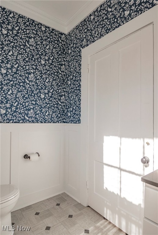 bathroom with vanity, crown molding, and toilet