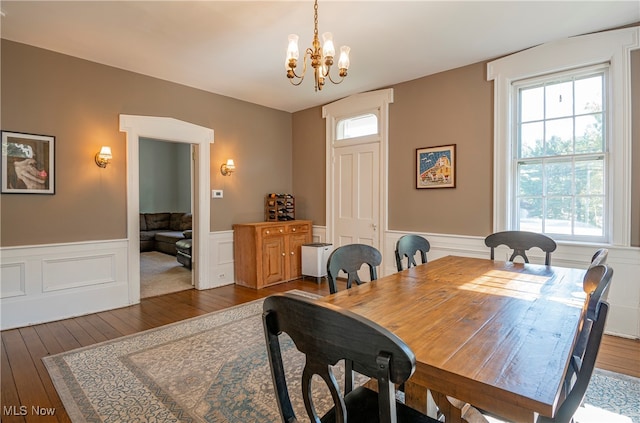 dining area with dark wood-type flooring and a notable chandelier