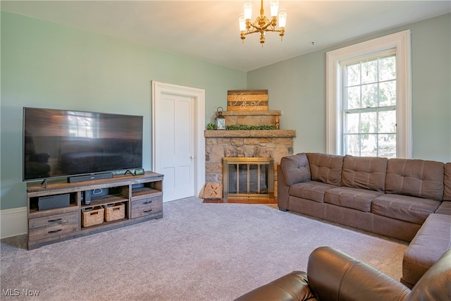 carpeted living room with an inviting chandelier and a stone fireplace