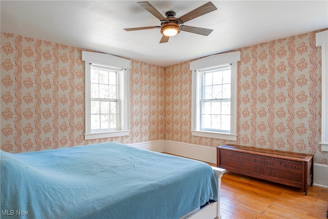 bedroom with hardwood / wood-style floors, multiple windows, and ceiling fan