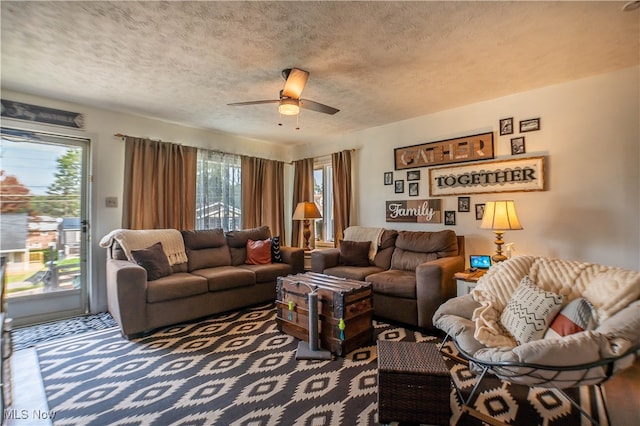 living room with carpet flooring, a textured ceiling, and ceiling fan