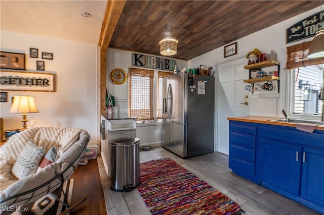 kitchen with stainless steel fridge, a healthy amount of sunlight, and light hardwood / wood-style flooring