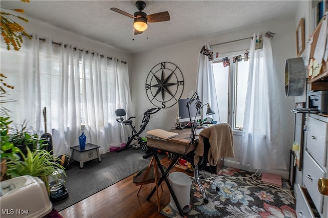 dining space featuring ceiling fan and dark wood-type flooring