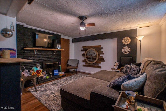 living room with ornamental molding, ceiling fan, wood-type flooring, and a textured ceiling