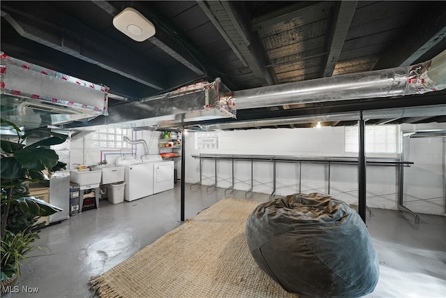 basement featuring independent washer and dryer and sink