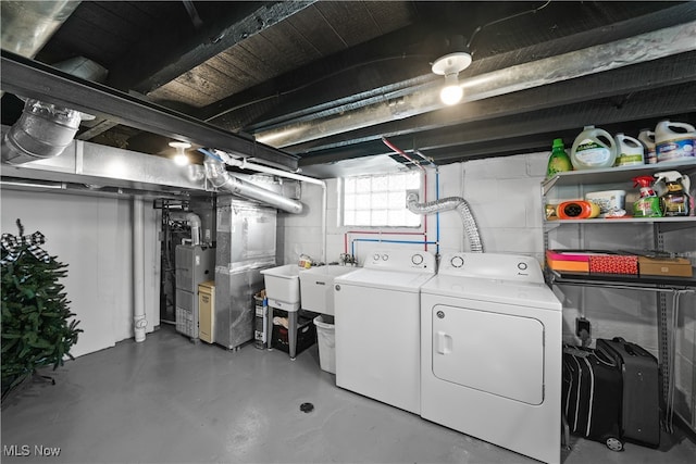 laundry room featuring heating unit and separate washer and dryer