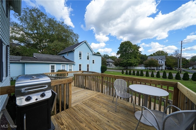 wooden terrace with a grill and a lawn