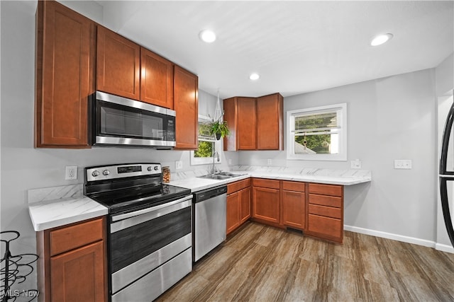 kitchen featuring light stone countertops, appliances with stainless steel finishes, dark hardwood / wood-style floors, and sink