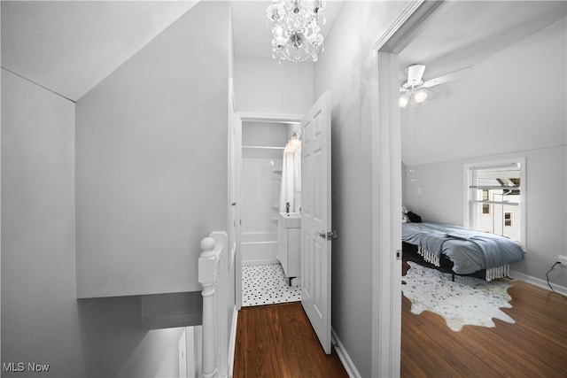 bathroom with ceiling fan with notable chandelier, vaulted ceiling, hardwood / wood-style flooring, and radiator heating unit