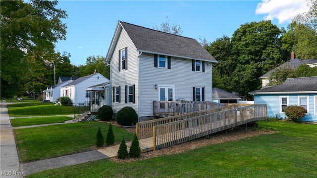 back of house featuring a deck and a lawn