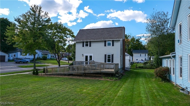 rear view of property featuring a yard and a deck